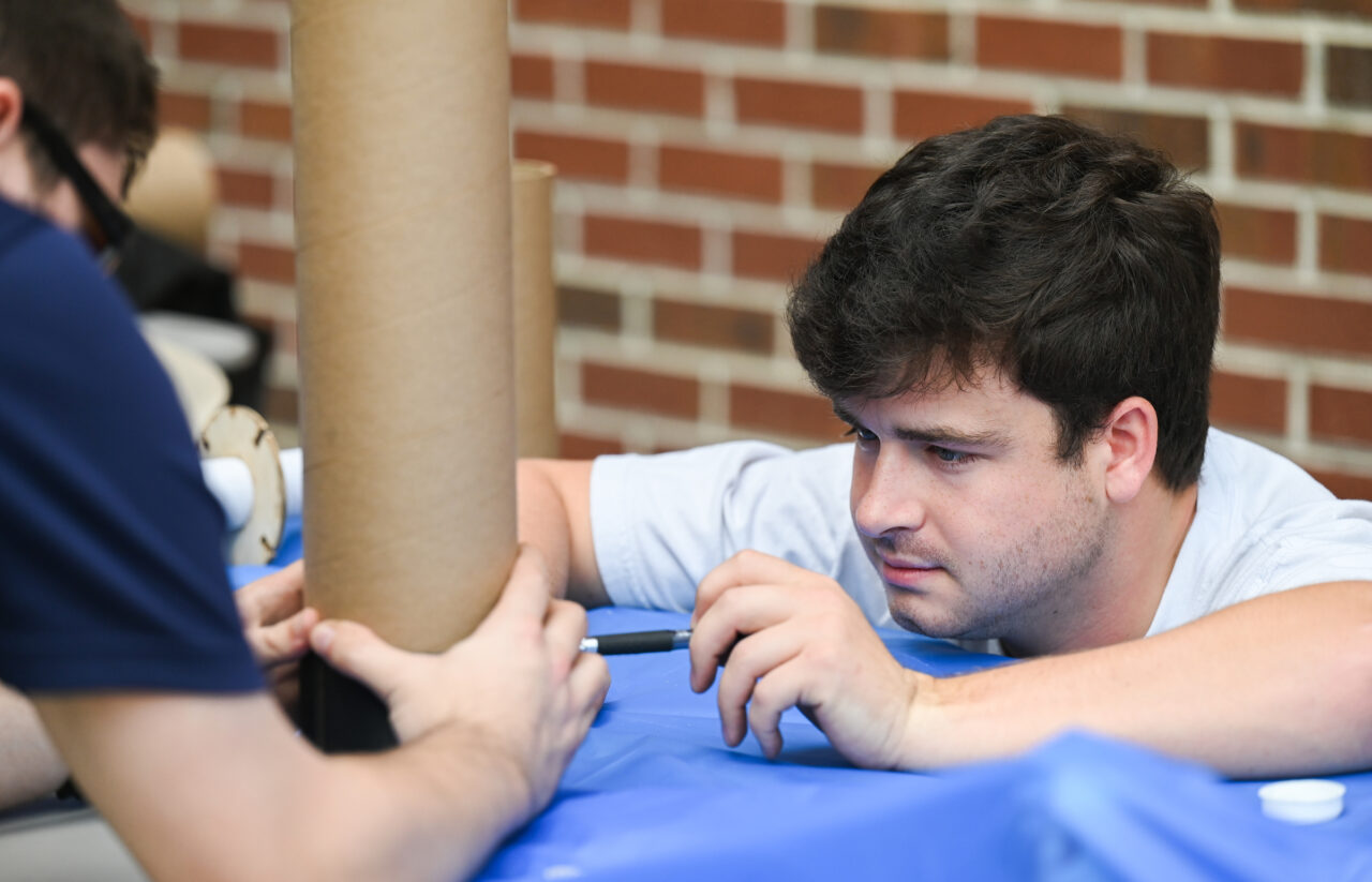 2023 NASA USLI Rocket Mocs Team members work Friday, Oct. 7, 2022 outside of the ECS building on their certification rockets in preparation for their competition.