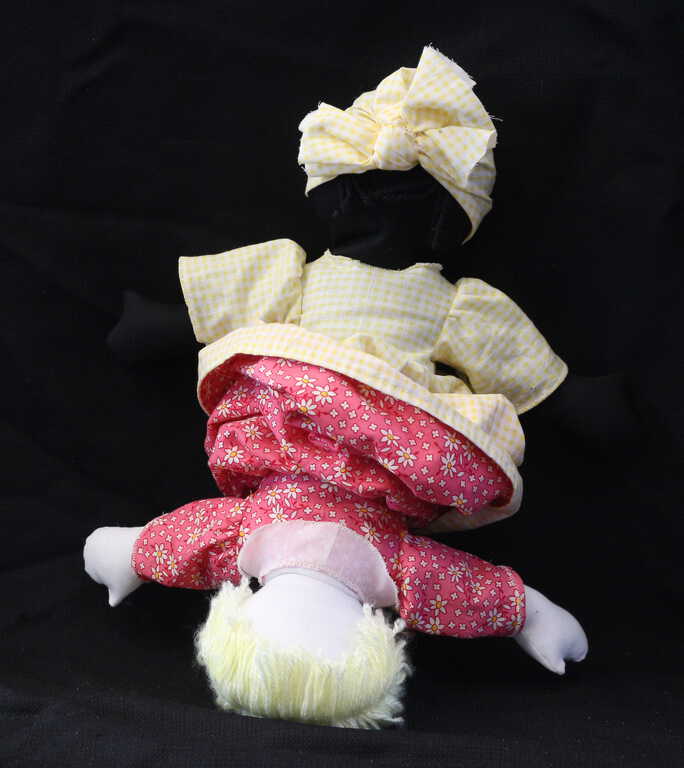 Topsy Turvy Dolls most likely originated in American plantations of the early 19th century. This doll has two heads and two bodies—one black and one white. The lining of one dress is the outside of the other’s, so the skirt flips over to conceal one body when the other is upright. Two dolls in one, yet only one can be played with at a time.