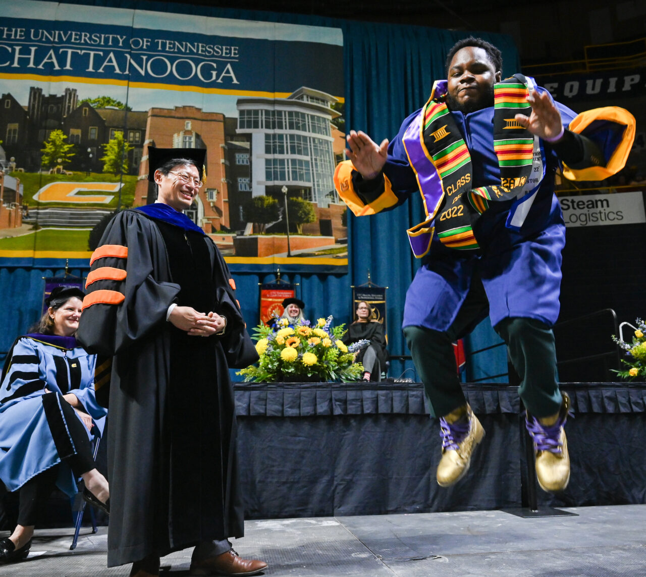 Deans Pamela Riggs-Gelasco left, and Daniel Pack watch as engineering student Reggie Marshall dances across the stage during the first of two University of Tennessee at Chattanooga undergraduate commencement ceremonies on Saturday, Dec. 17, 2022 in McKenzie Arena.