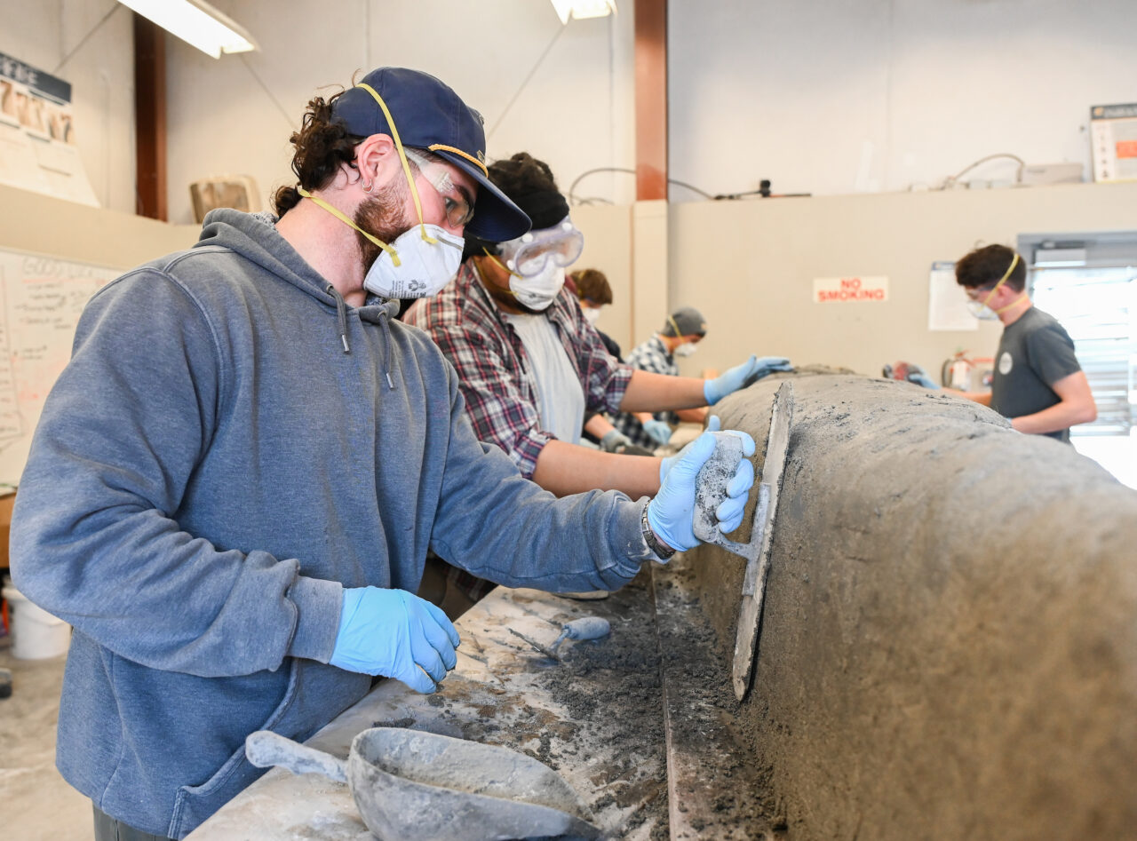 UTC civil engineering students work on a concrete canoe in preparation for competition in the American Society of Civil Engineers Mid-South Student Symposium. Photo by Angela Foster.