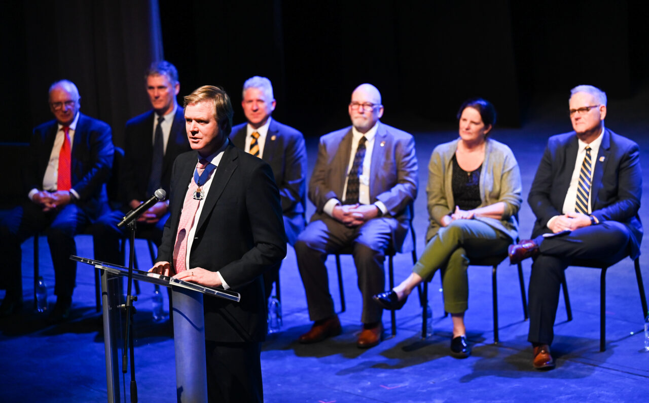 Senior Patron Duncan Sandys, former Lord Mayor of the City of Westminster talks Wednesday, March 22, 2023 in the Hayes Concert Hall while presenting the Marching Mocs with their official invitation to participate in the London New Year’s Day Parade.
