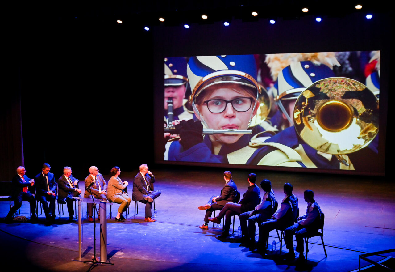 Representatives from the London Parade office and the city of London along with UTC representatives, watch footage of the London Parade Wednesday, March 22, 2023 in the Hayes Concert Hall before presenting the Marching Mocs with their official invitation to participate in the London New Year’s Day Parade.