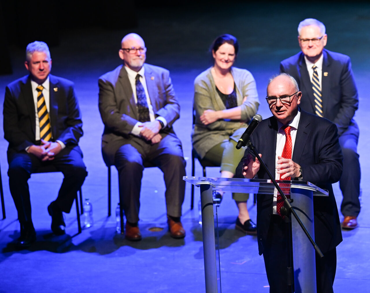 Bob Bone, parade founder and chair, talks Wednesday, March 22, 2023 in the Hayes Concert Hall before London officials present the Marching Mocs with their official invitation to participate in the London New Year’s Day Parade.