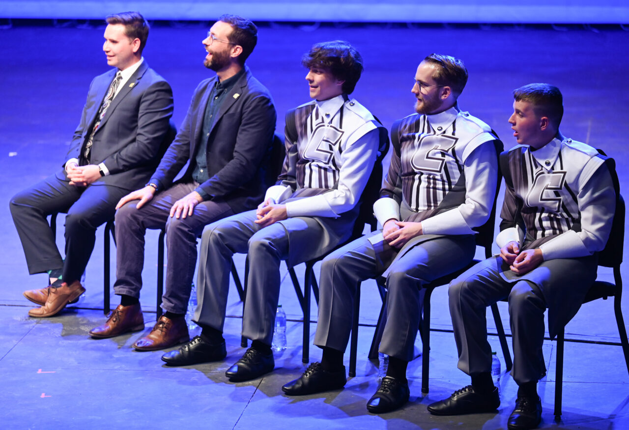 Representatives from the London Parade office and the city of London talk Wednesday, March 22, 2023 in the Hayes Concert Hall while presenting the Marching Mocs with their official invitation to participate in the London New Year’s Day Parade.