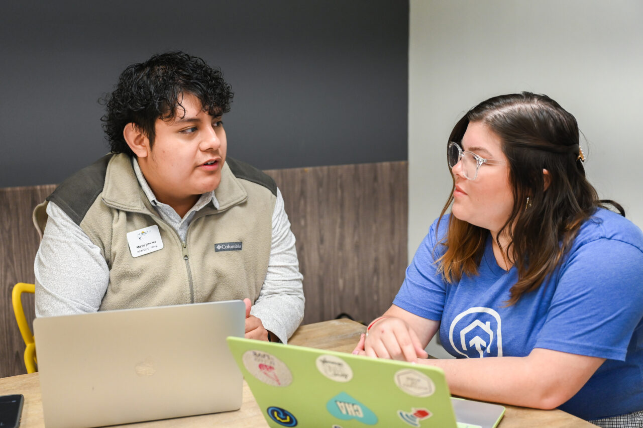 Mateo Jimenez and Melissa Callejas, Hispanic outreach specialist for The Enterprise Center, meet about a Hispanic outreach brochure model to inform the community about digital equity. Photo by Angela Foster.