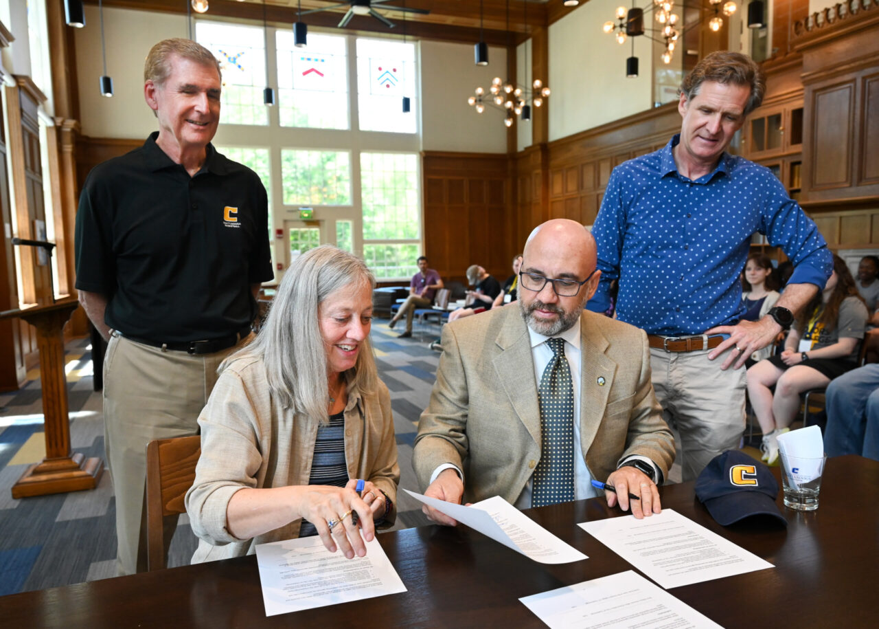 Linda Frost, dean of the Honors College, and Steve Wilson, director of Innovation and Special Projects for the city of Chattanooga, sign a strategic partnership agreement Saturday, Aug. 19, 2023, in the Guerry Center Reading Room. Chancellor Steven Angle and Chatannoga Mayor Tim Kelly look on. Photo by Angela Foster.