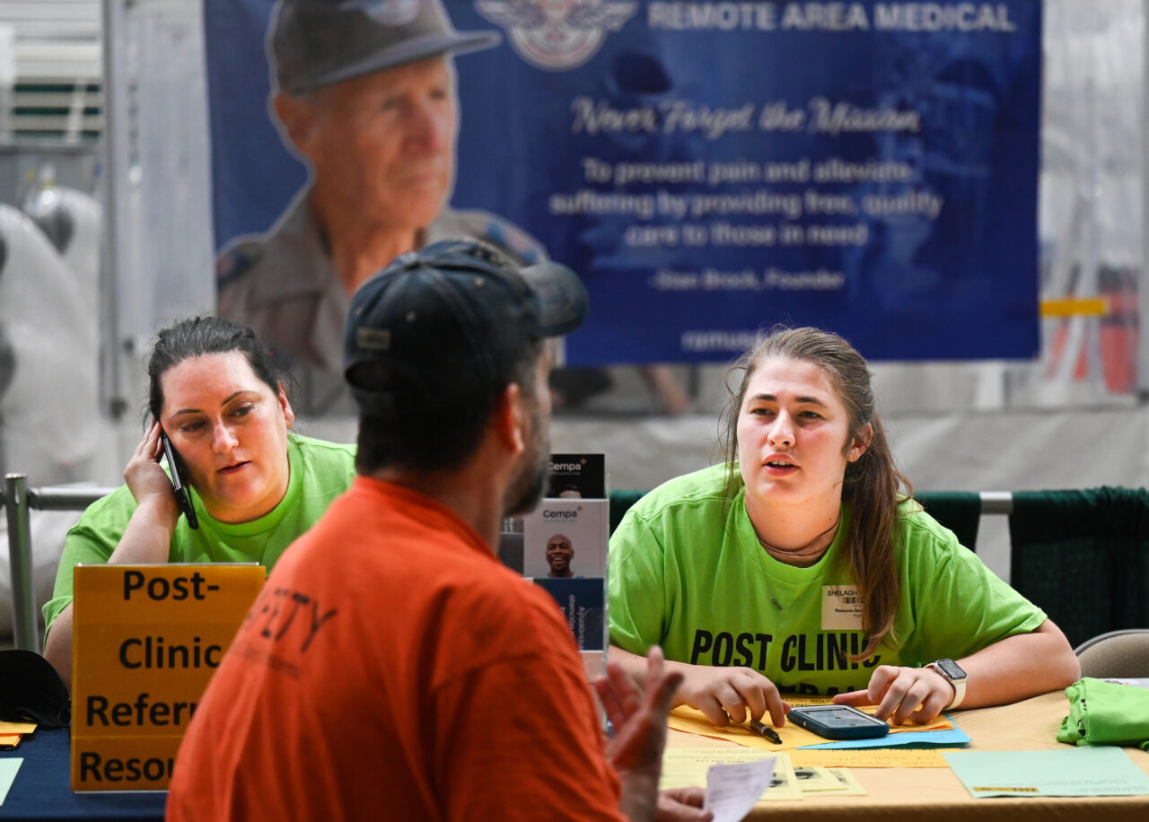 Master of Social Work graduate student Shelagh Watkins, right, talks to a patient at the Remote Area Medical (RAM) pop-up clinic on Saturday, Sept. 9, at the Camp Jordan Arena in East Ridge. Photo by Angela Foster.
