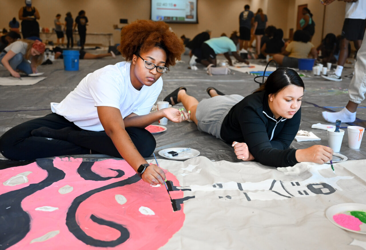 Students paint Homecoming banners Sunday, Oct. 1, 2023 in the University Center.