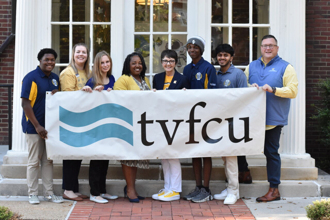 TVFCU's Dionne Jenkins (yellow sweater), UTC staff and MOC Academy students recognizing TVFCU’s $10,000 gift to MOC Academy on Mocs Give Day.
