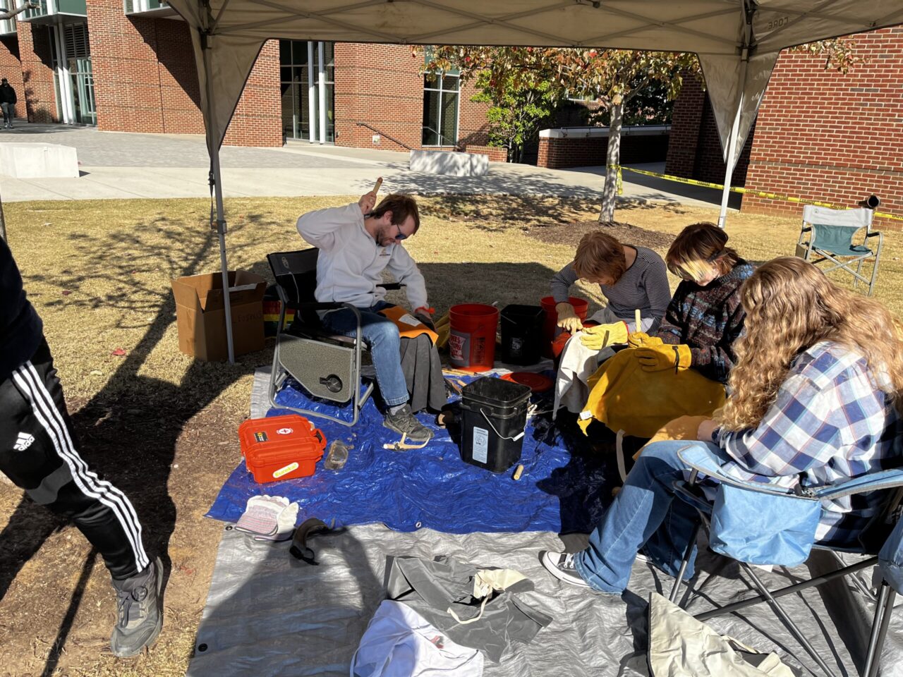 UC Foundation Associate Professor Morgan Smith demonstrates flint-knapping techniques to students to make projectile points and other stone tools. Photo credit: Dr. Brooke Persons.