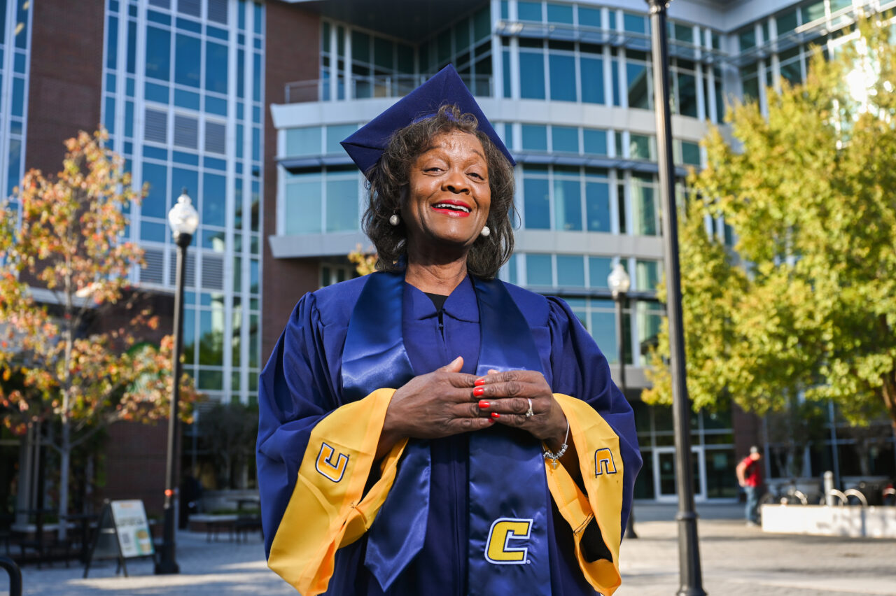 Lorena Upshaw poses in her cap and gown in front of the UTC Library in early November. Upshaw will be the recipient of a Bachelor of Applied Science: Applied Leadership degree during UTC fall commencement ceremonies. Photo by Angela Foster.
