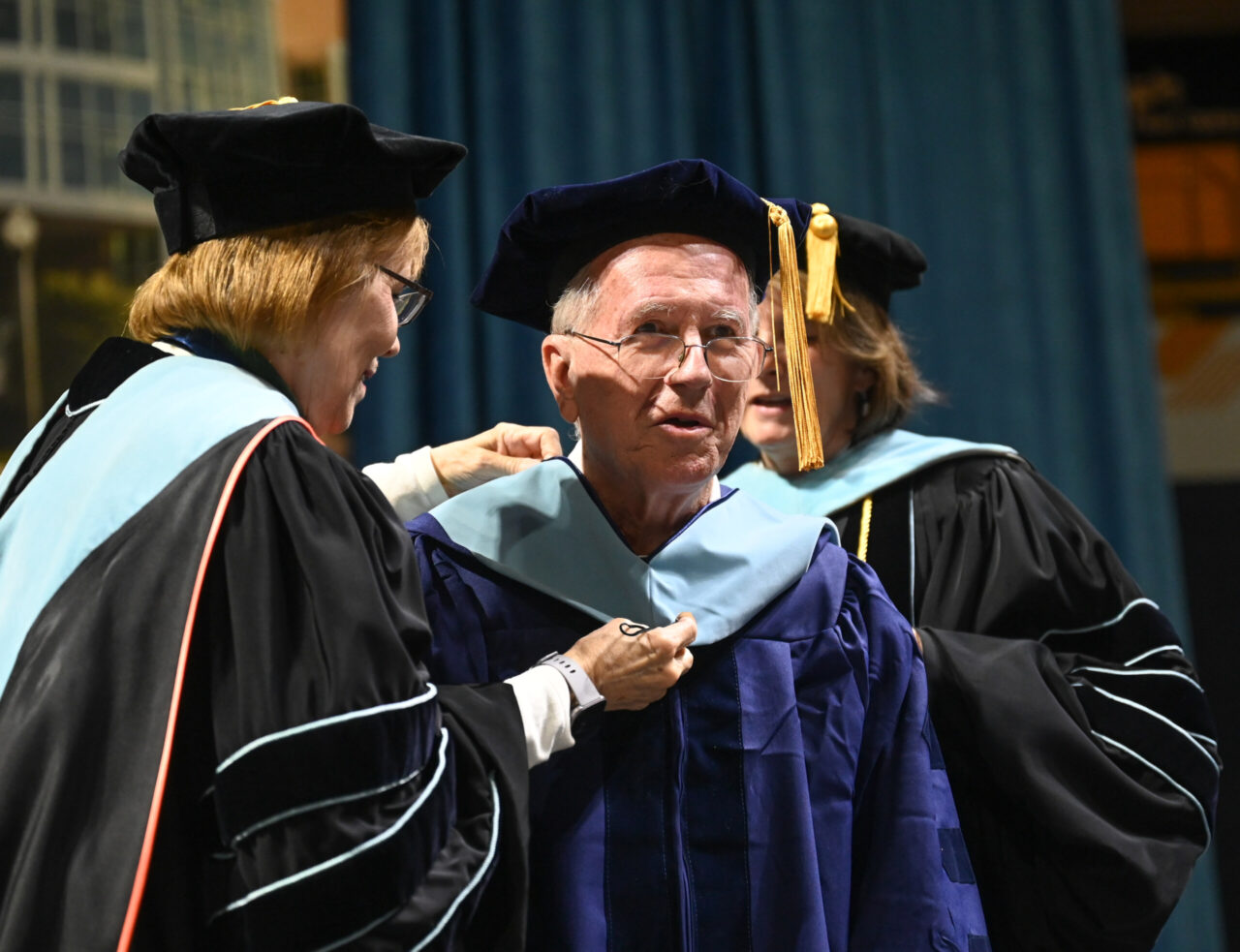 Tony Galloway is hooded by Dean Valerie Rutledge, left, and Dr. Beth Crawford during UTC Graduate School commencement ceremonies on Friday, Dec. 15. Photo by Angela Foster.