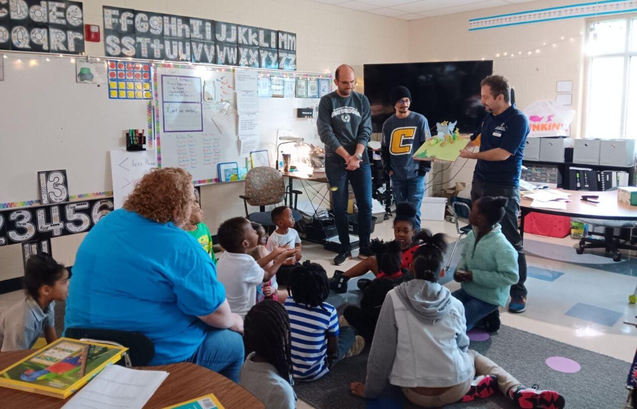 UTC graduate research assistants Ege Can Ek, left, and Atal Bhowmik and Assistant Professor of Mechanical Engineering Murat Barisik read to Orchard Knob Elementary School students. Photo credit: Dr. Sandra Affare.