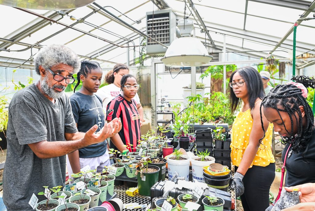Dr. Jose Barbosa and members of the ANGELS camp work in the Teaching and Learning Garden near Holt Hall during the summer of 2023.