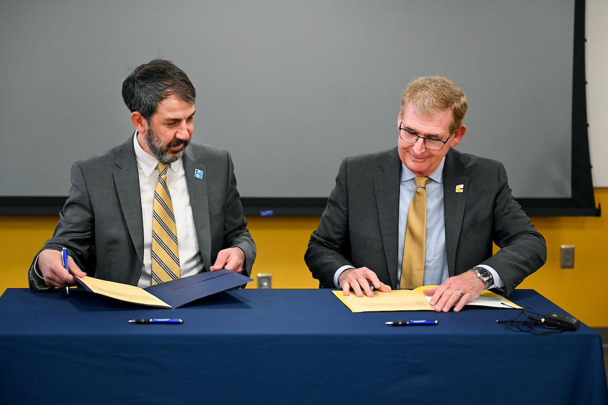 Hamilton County Schools Superintendent Justin Robertson, left, and UTC Chancellor Steven Angle sign an MOU Wednesday, April 3, 2024 in Hunter Hall on the University of Tennessee at Chattanooga campus.