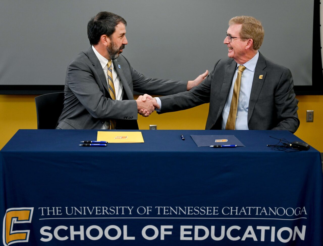 Hamilton County Schools Superintendent Justin Robertson, left, and UTC Chancellor Steven Angle shake hands following the signing of an MOU to extend the sponsorship of UTC’s Future Ready Institute in Teaching and Learning at Tyner Academy. The signing ceremony took place on Wednesday, April 3, on the UTC campus. Photo by Angela Foster.