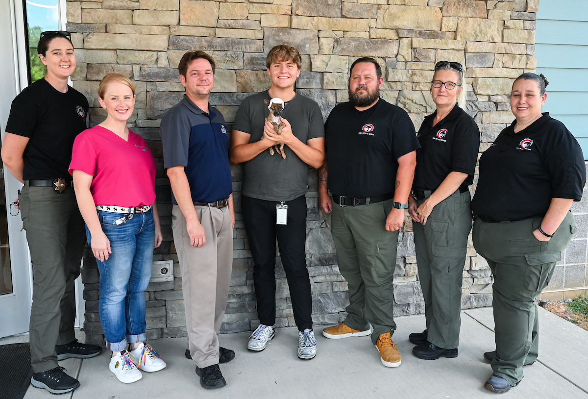 From left: Humane Educational Society Director of Animal Protection Services Caroline Smith, HES Director of Veterinary Services Sarah Callahan, Dr. Trevor Elliott, Connor Mackey (holding Niblet), HES animal services officers Stephen Nunley, Dr. Samantha Blair and Leigh Stacy.