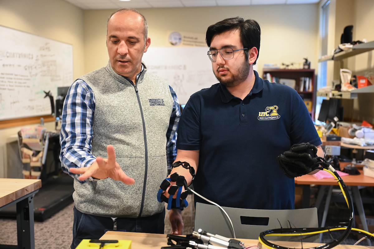 Dr. Erkan Kaplanoglu, left, and Juan Pena work on the hand rehabilitation system. Photo by Angela Foster.