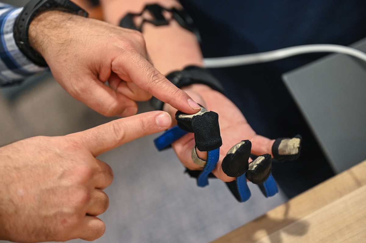 Dr. Erkan Kaplanoglu explains how the prosthetic glove works while Juan Pena wears it.