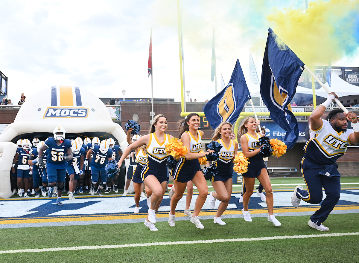 Mocs football players and cheerleaders enter the Finley Stadium field.