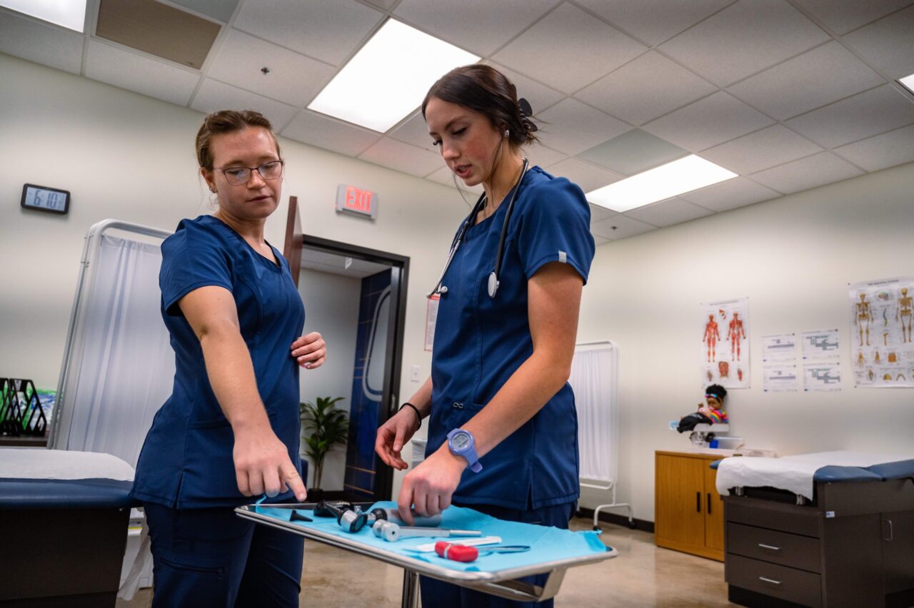 CMA students Riley Ottinger (left) and Skylen Casrill learn to use medical instruments. Photo by Noah Camacho.
