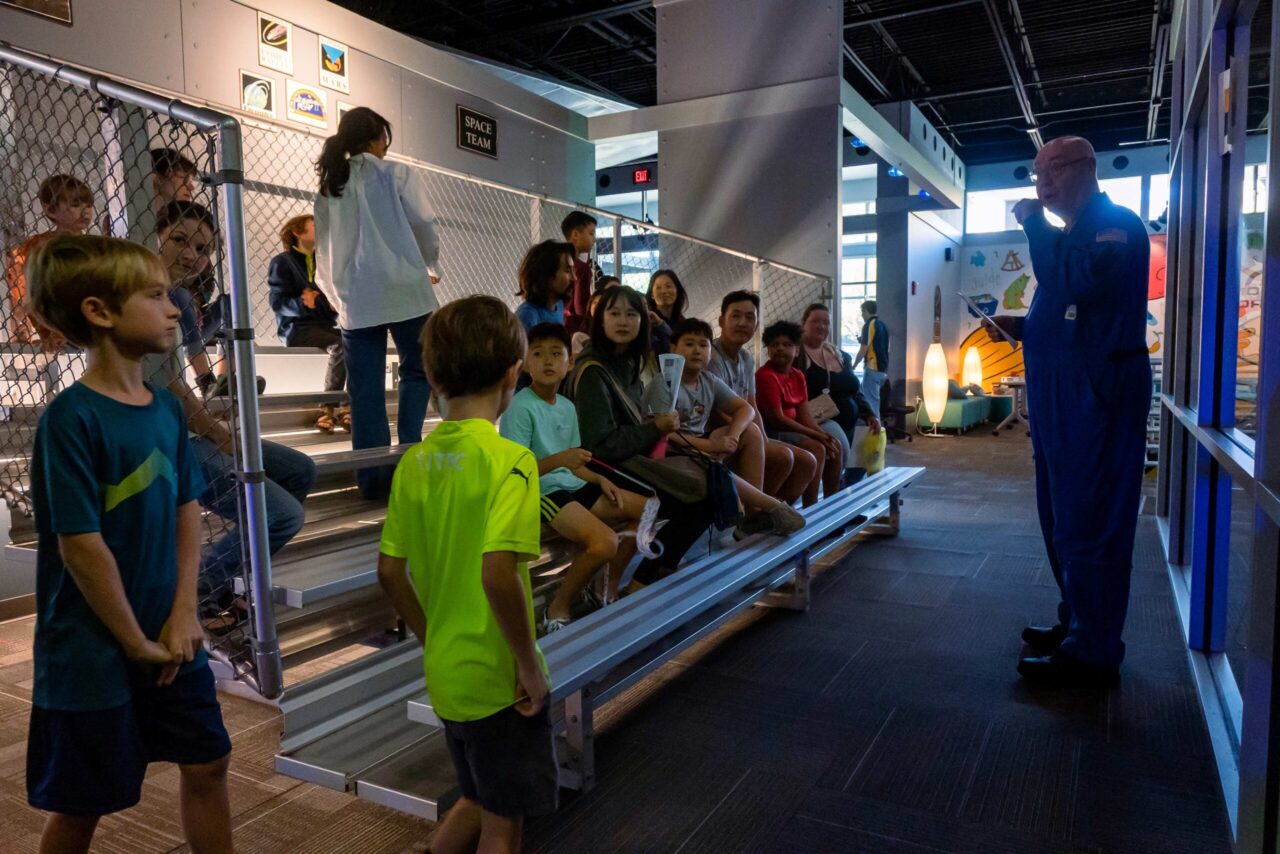 Challenger STEM Learning Center resident space educator Bill Floyd introduces STEAMagination visitors to the mission to Mars exhibit. Photo by Noah Camacho.