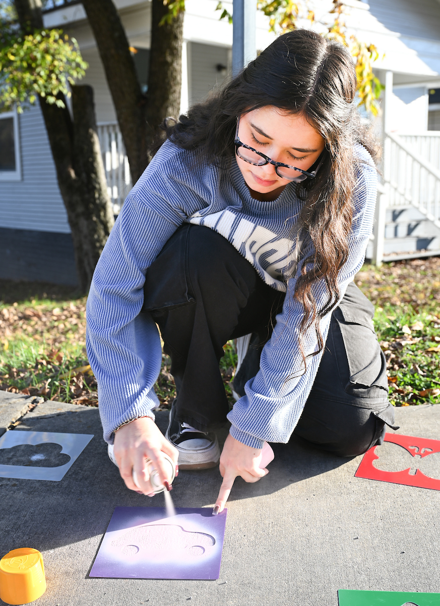 Students in Chandra Ward’s Innovation in Honors class work Monday, Nov. 18, 2024 to put up tactical urbanism traffic calming installations in the Oak Grove neighborhood.