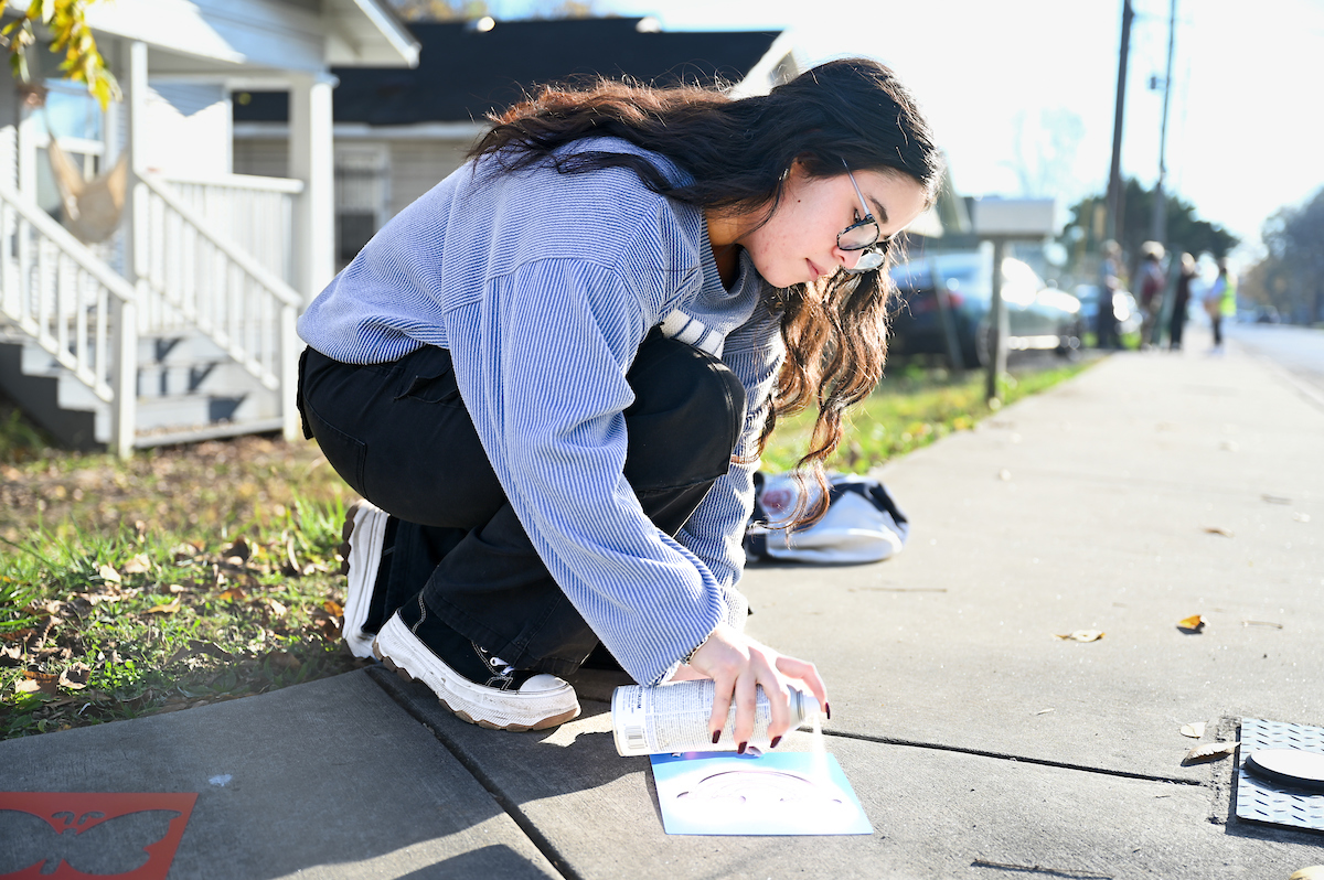 Joana Da Silva (right) helps paint and hang signs in the Oak Grove neighborhood.