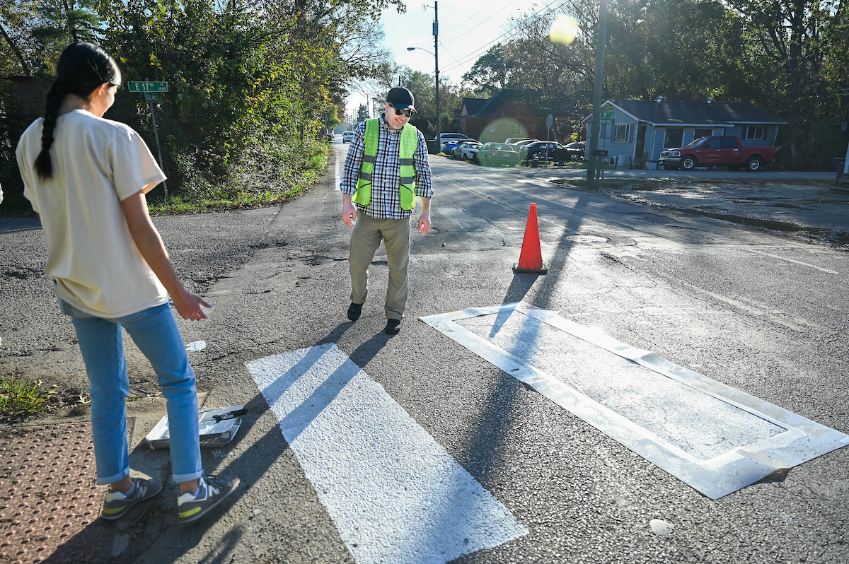 Students in Chandra Ward’s Innovation in Honors class work Monday, Nov. 18, 2024 to put up tactical urbanism traffic calming installations in the Oak Grove neighborhood.