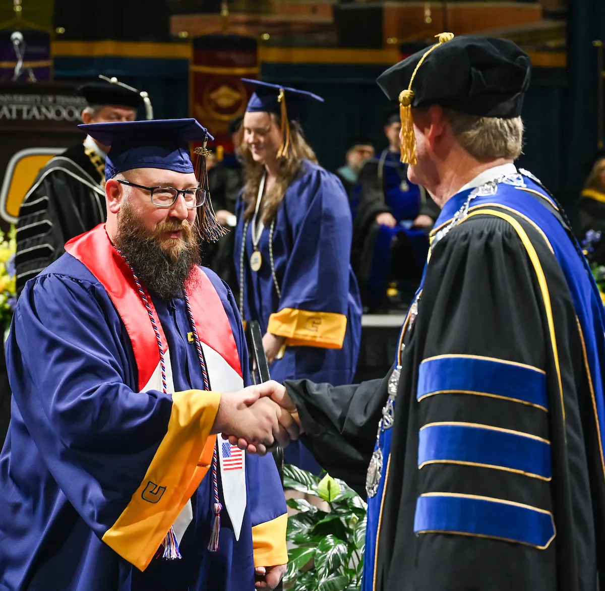 Brad Crush, left, shakes hands with Chancellor Steve Angle during UTC undergraduate commencement ceremonies. Crush, a member of the U.S. Marines from 2012-2016, received a bachelor's degree in history. Photo by Angela Foster.