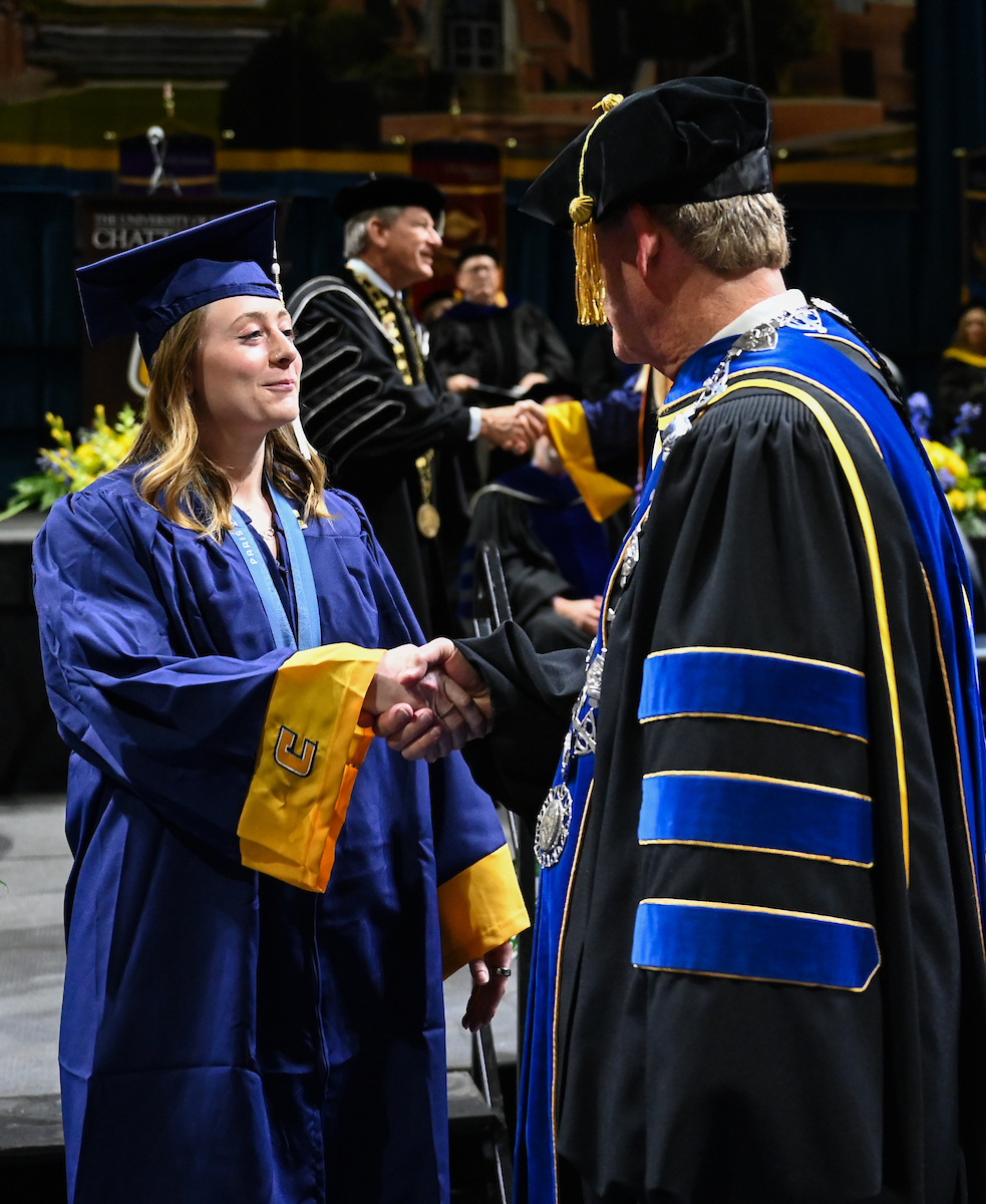 University of Tennessee at Chattanooga student and Olympic gold medalist Olivia Reeves, left, shakes Chancellor Steven Angle’s hand during the undergraduate graduation ceremony on Saturday, Dec. 14, 2024 in McKenzie Arena