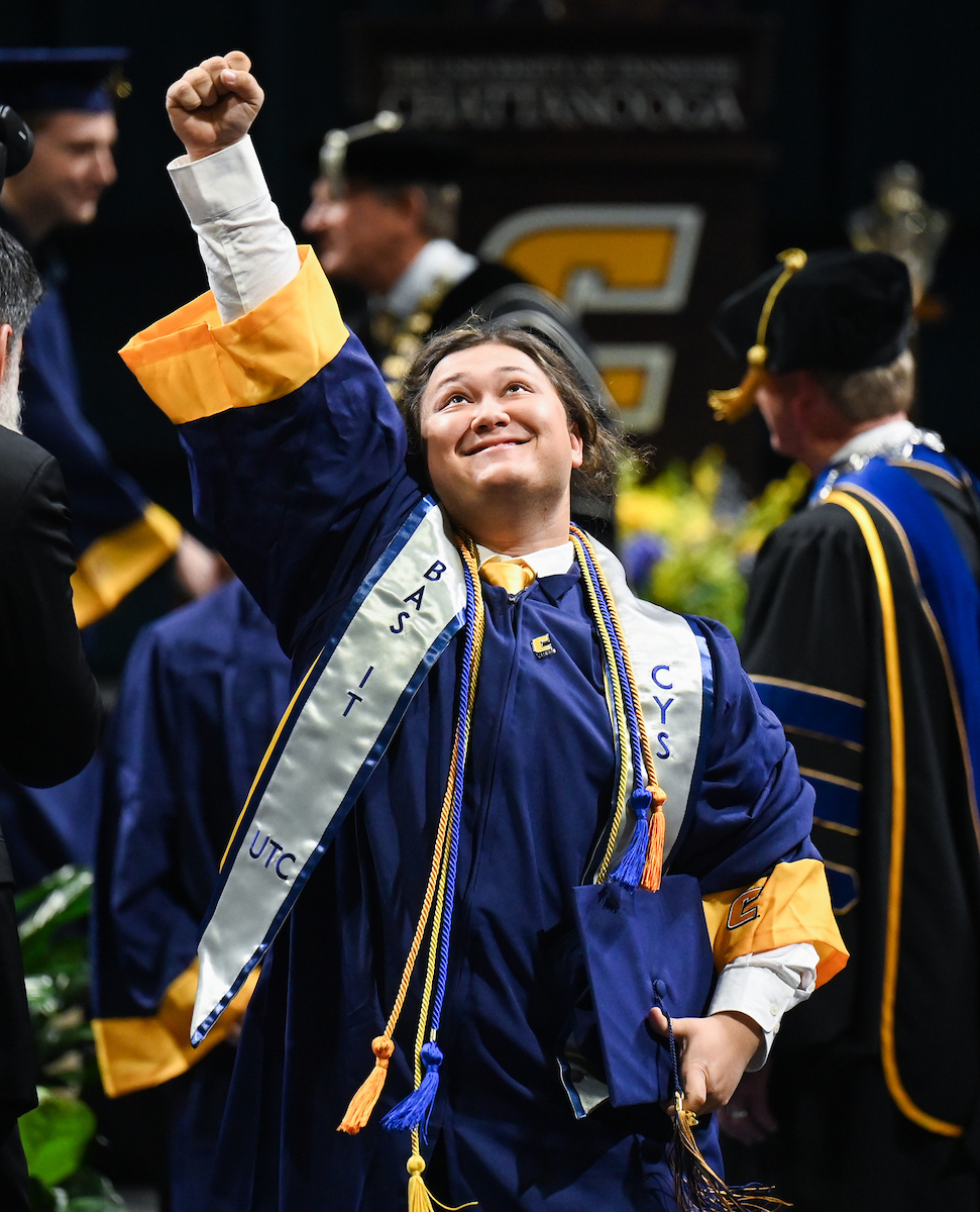 University of Tennessee at Chattanooga student Joshua Dressel celebrates on the way back to his seat Saturday, Dec. 14, 2024 during the undergraduate commencement ceremony in McKenzie Arena.