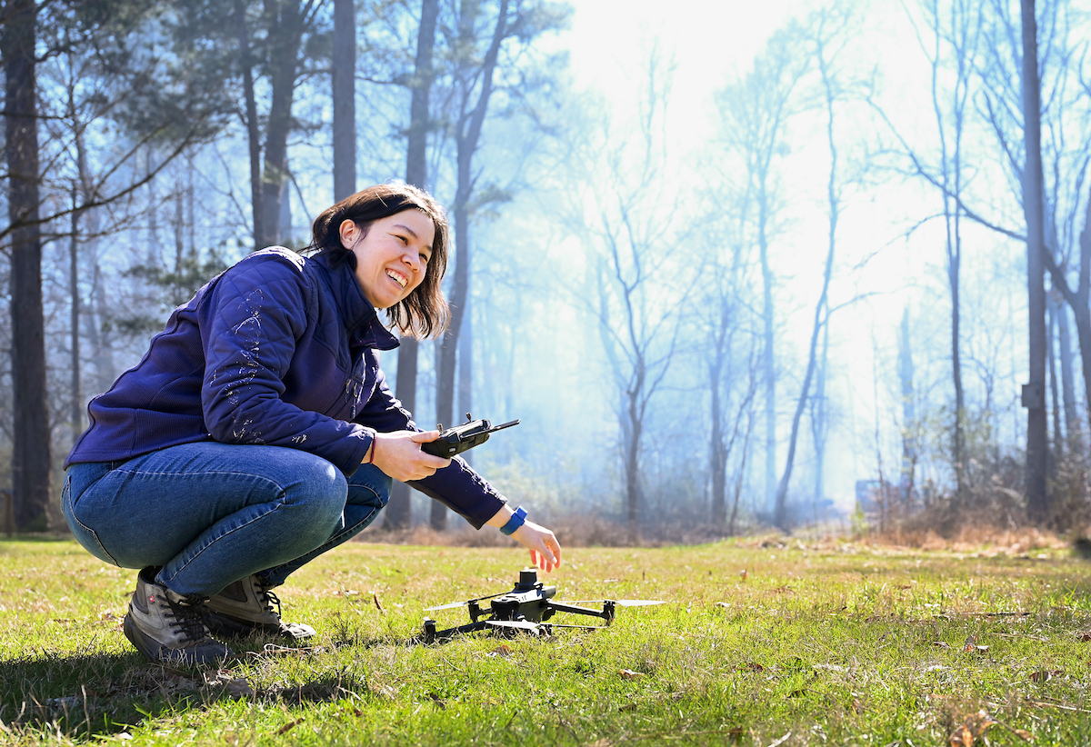 Nyssa Hunt prepares to fly a drone over a controlled burn at Audubon Acres.
