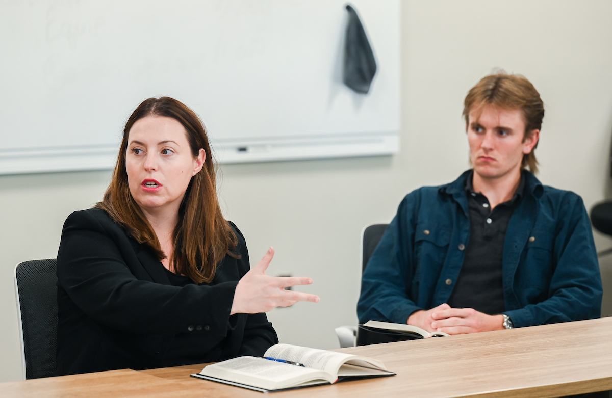 Dr. Claudia Kramer leads a Phillips Scholars in Free Enterprise discussion as Gage Keeble listens.