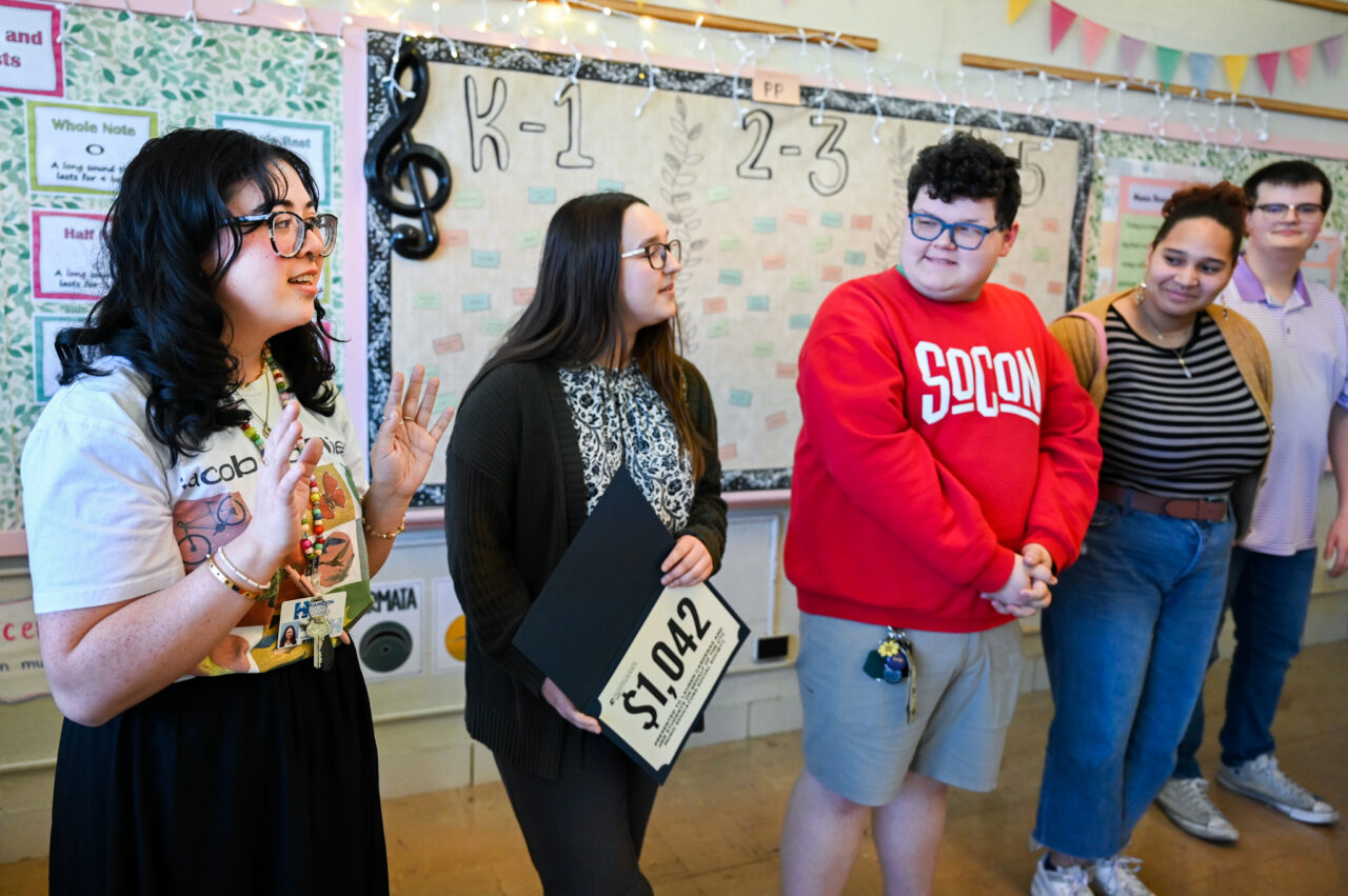 Music students and professor Alison Allerton deliver a $1000 check to Lauren Cardenas, music teacher and recent graduate, Friday, Feb. 28, 2025 at Dupont Elementary School.