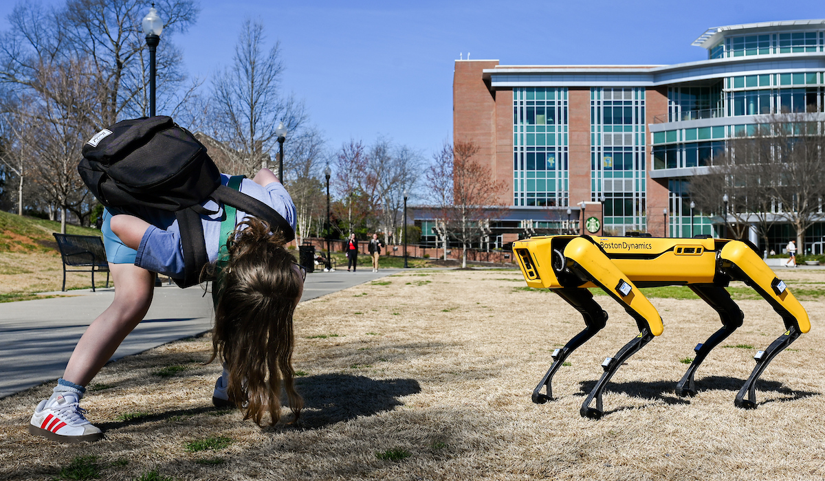 Gokhan Erdemir, Ann McAbee and Trevor Kight work Friday, Feb. 28, 2025 on Chamberlain Field to gather data from two robotic dogs, Spot and Goddard. The data will be compared against data from real dogs and used to make the robots move more like real dogs.