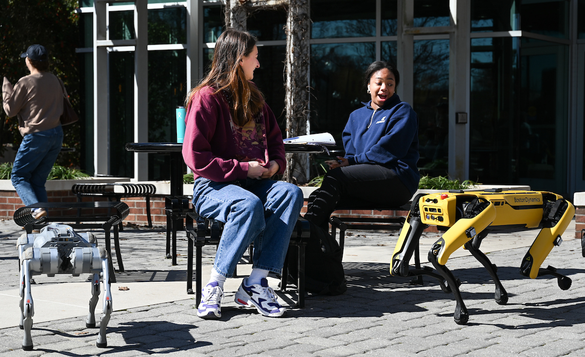 Gokhan Erdemir, Ann McAbee and Trevor Kight work Friday, Feb. 28, 2025 on Chamberlain Field to gather data from two robotic dogs, Spot and Goddard. The data will be compared against data from real dogs and used to make the robots move more like real dogs.