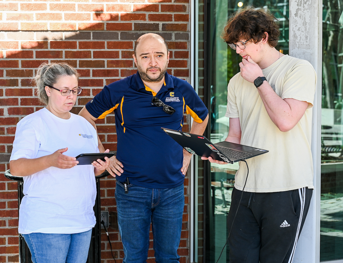 Gokhan Erdemir, Ann McAbee and Trevor Kight work Friday, Feb. 28, 2025 on Chamberlain Field to gather data from two robotic dogs, Spot and Goddard. The data will be compared against data from real dogs and used to make the robots move more like real dogs.