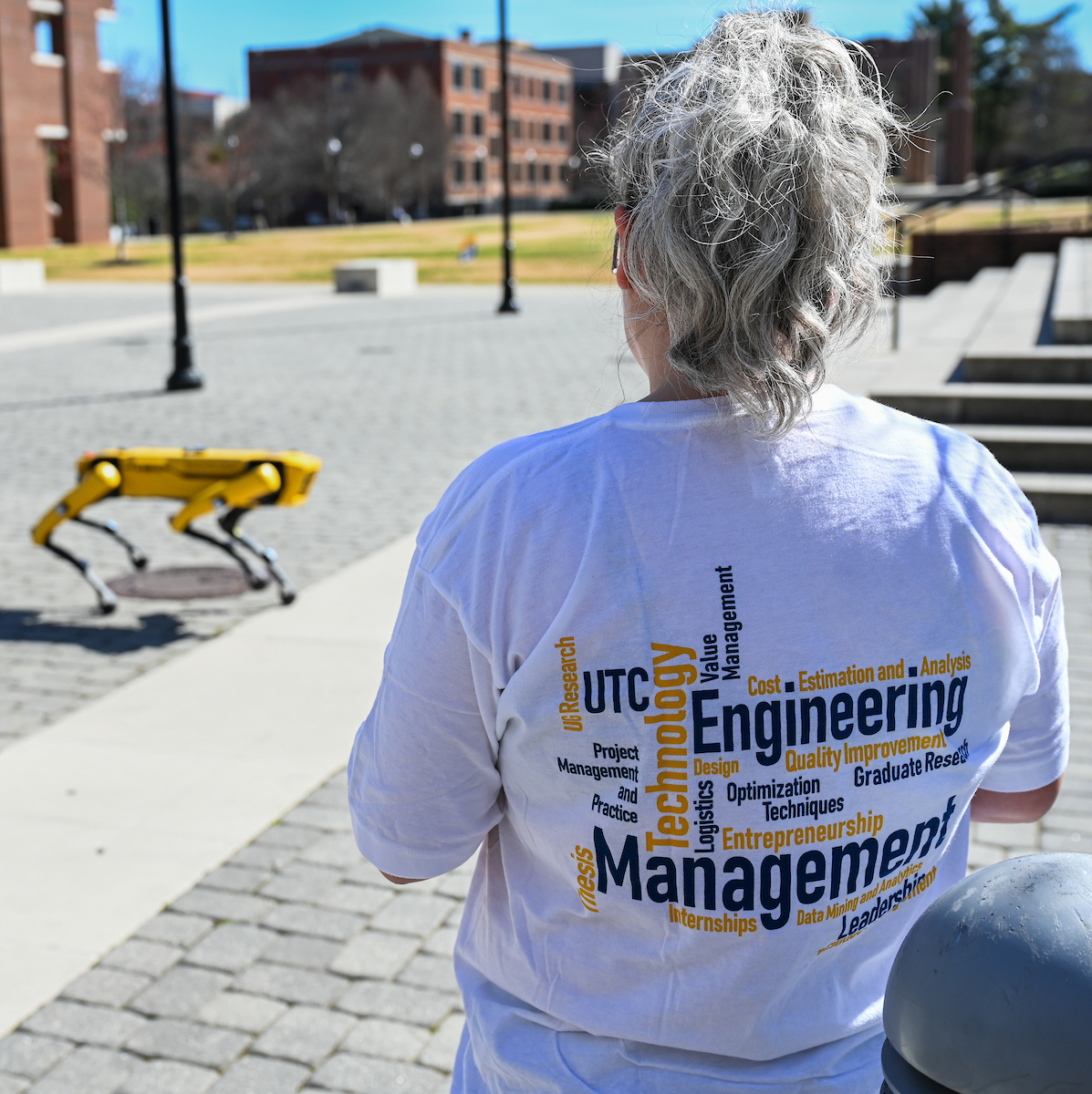 Gokhan Erdemir, Ann McAbee and Trevor Kight work Friday, Feb. 28, 2025 on Chamberlain Field to gather data from two robotic dogs, Spot and Goddard. The data will be compared against data from real dogs and used to make the robots move more like real dogs.