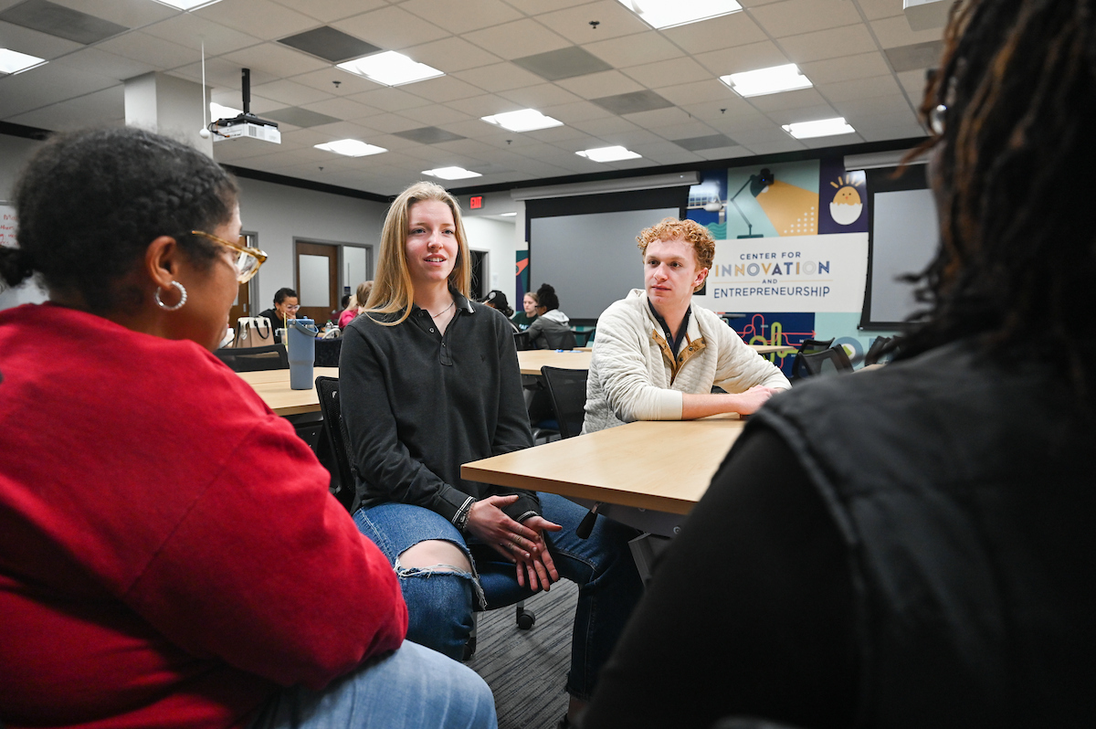 Ana Morris and Graham Davis work with UVI entrepreneurs Marie Mott (burgundy shirt) and Shawanna Kendrick.