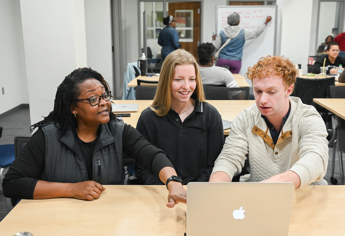 Local business owner Shawanna Kendrick, left, works with Urban Vision Initiative student consultant interns Ana Morris and Graham Davis during a Feb. 10 meeting in the Center for Innovation and Entrepreneurship. Photo by Angela Foster.