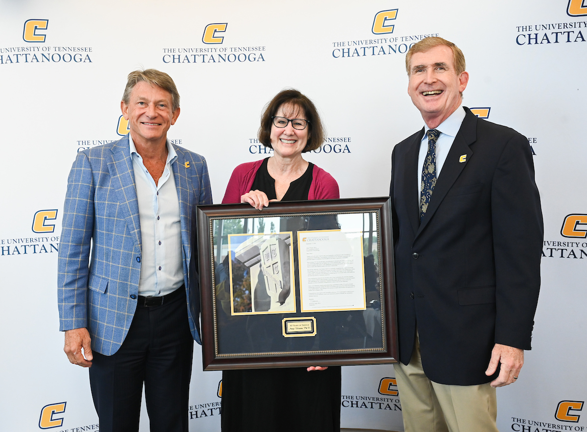 Dr. Amye Warren, flanked by UT System President Randy Boyd and Chancellor Steve Angle, was honored for 40 years of service at the September 2024 UTC Service Awards Luncheon.