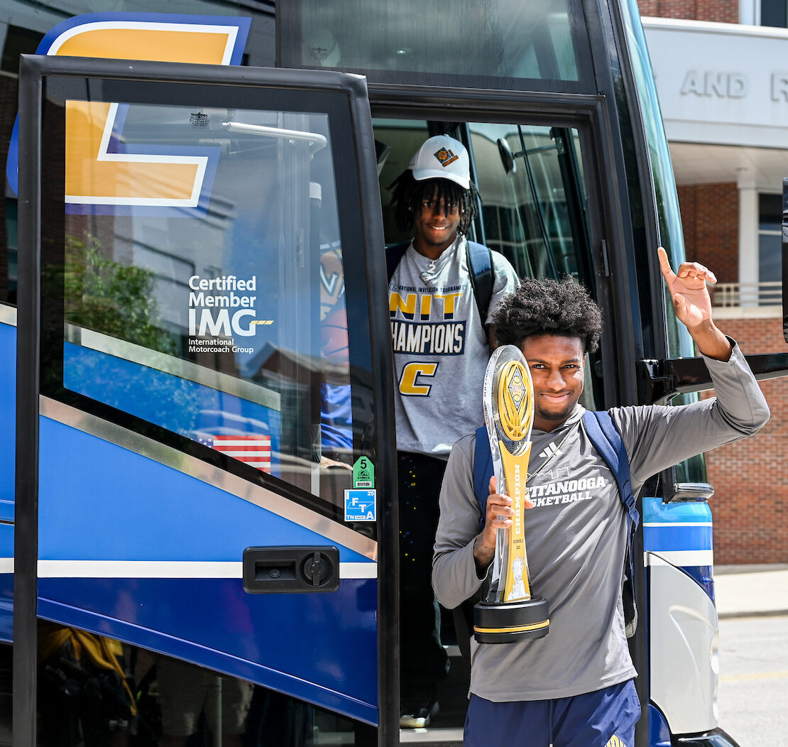 Honor Huff (right) exits the team bus at the campus celebration.