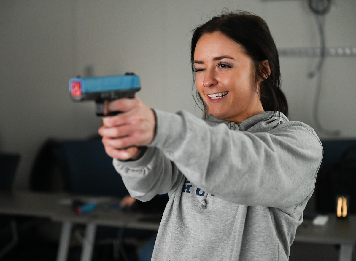 Atlee Dean, student in the Master of Criminal Justice program, tries out the simulated shooting range.
