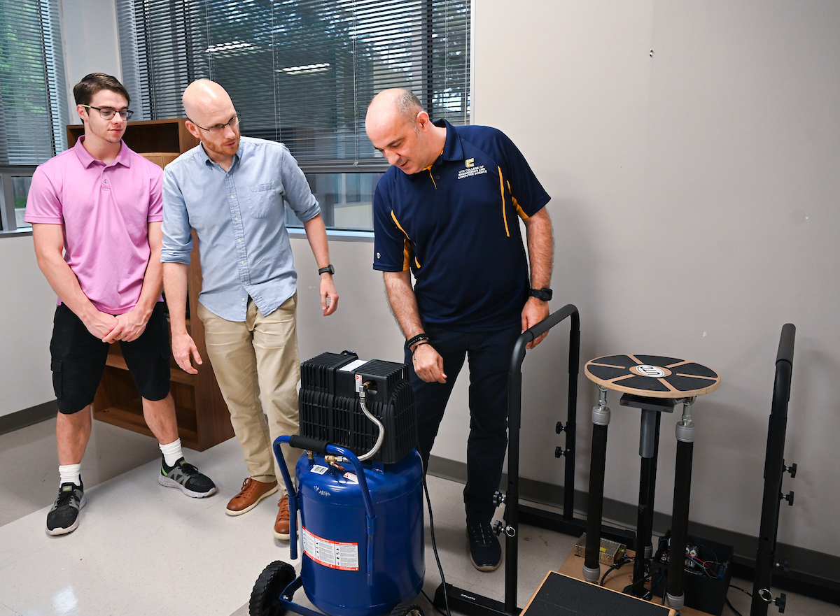 Mechatronics major Austin McDade, left, Dr. Max Jordon and Dr. Erkan Kaplanoglu demonstrate the pneumatically powered balance board. Photo by Angela Foster.
