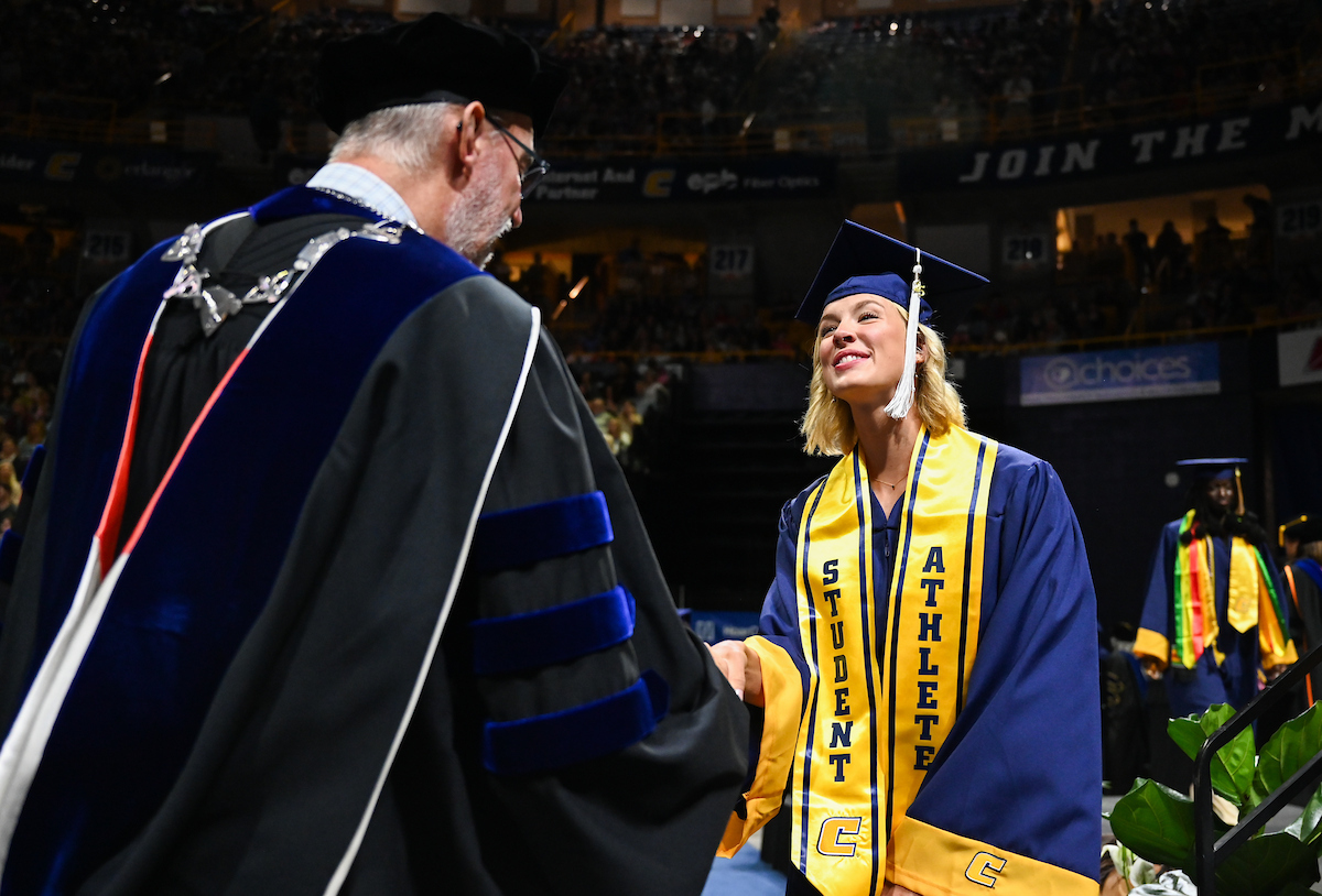Kit Gresham shakes interim Chancellor Robert Dooley’s hand during the first of two undergraduate ceremonies Saturday, May 3, 2025 in McKenzie Arena at the University of Tennessee at Chattanooga.