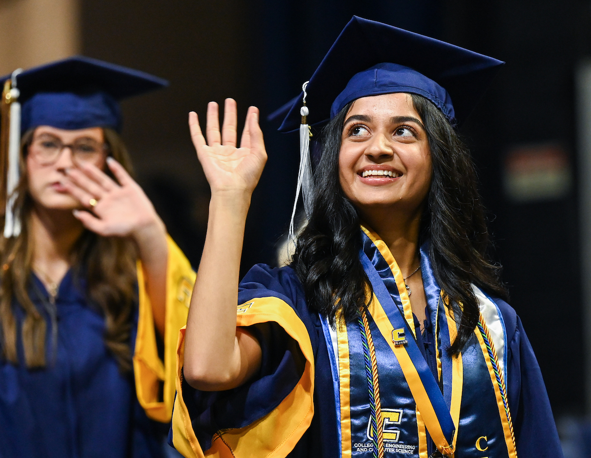 Prisha Purohit, Computer Science major, waves on her way into the first of two undergraduate ceremonies Saturday, May 3, 2025 in McKenzie Arena at the University of Tennessee at Chattanooga.