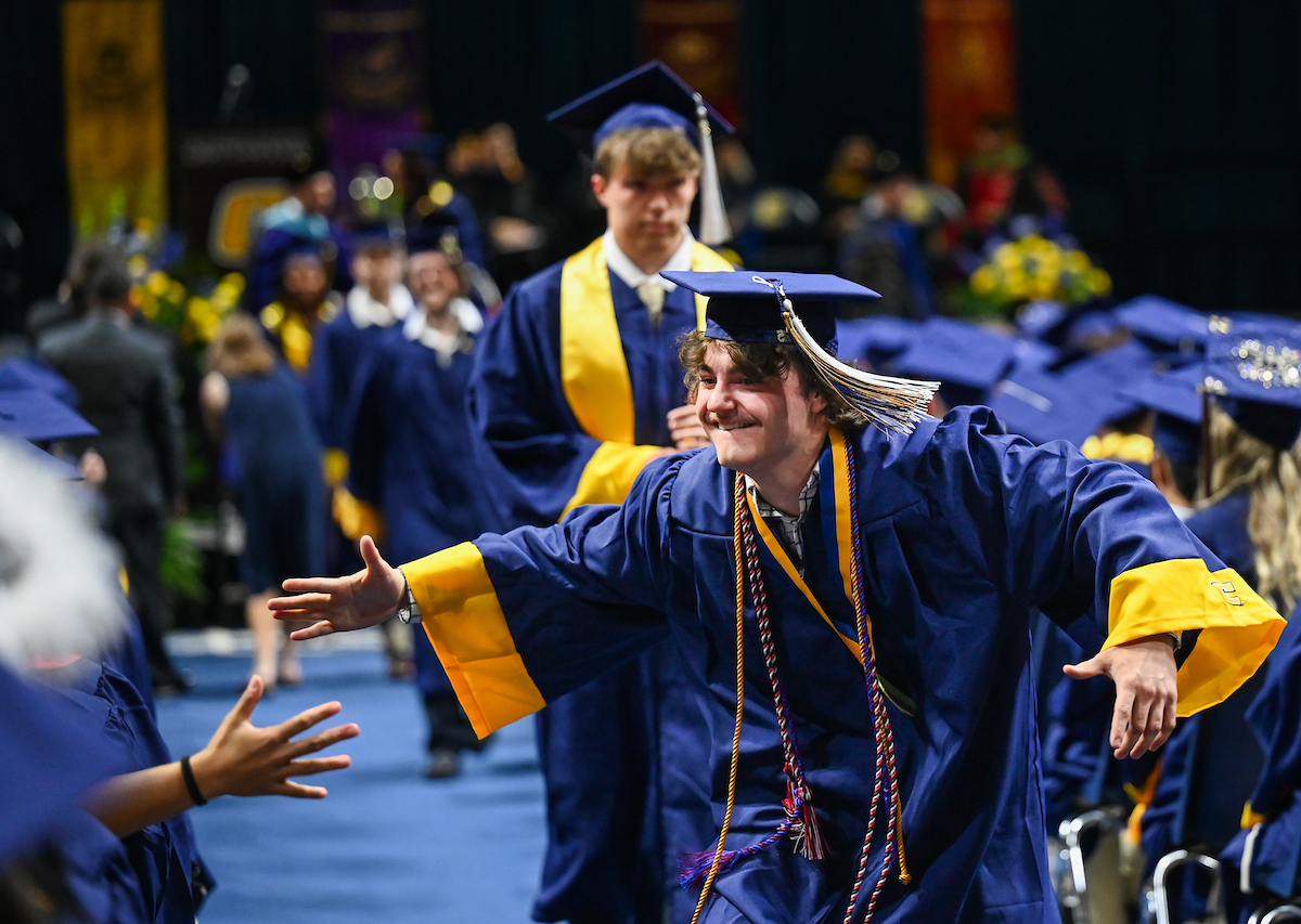Justin Laporta greets a friend on the way back to his seat during the first of two undergraduate ceremonies Saturday, May 3, 2025 in McKenzie Arena at the University of Tennessee at Chattanooga.