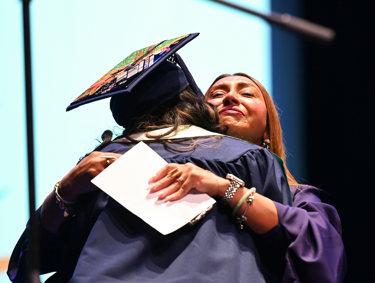 Principal Arielle Hayes hugs Kambriah Reynolds after the graduating senior spoke on behalf of the first cohort of University High. Photo by Angela Foster.