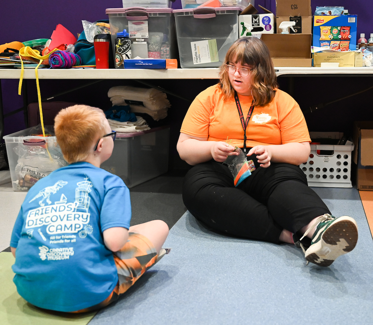 Psychology student Joy David works with a Friends' Discovery Camps camper at the Creative Discovery Museum.